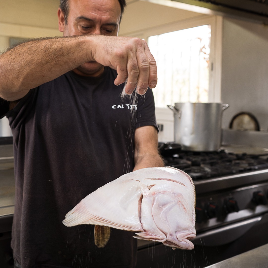 Un dels cuiners de Cal Tito elaborant una de les receptes tradicionals de peix